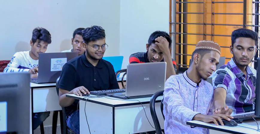 Students at desks with laptops during a session