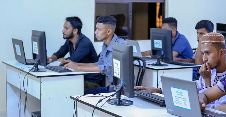 Two students side by side at their monitors