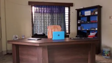 A desk and laptop by the window in the centre office